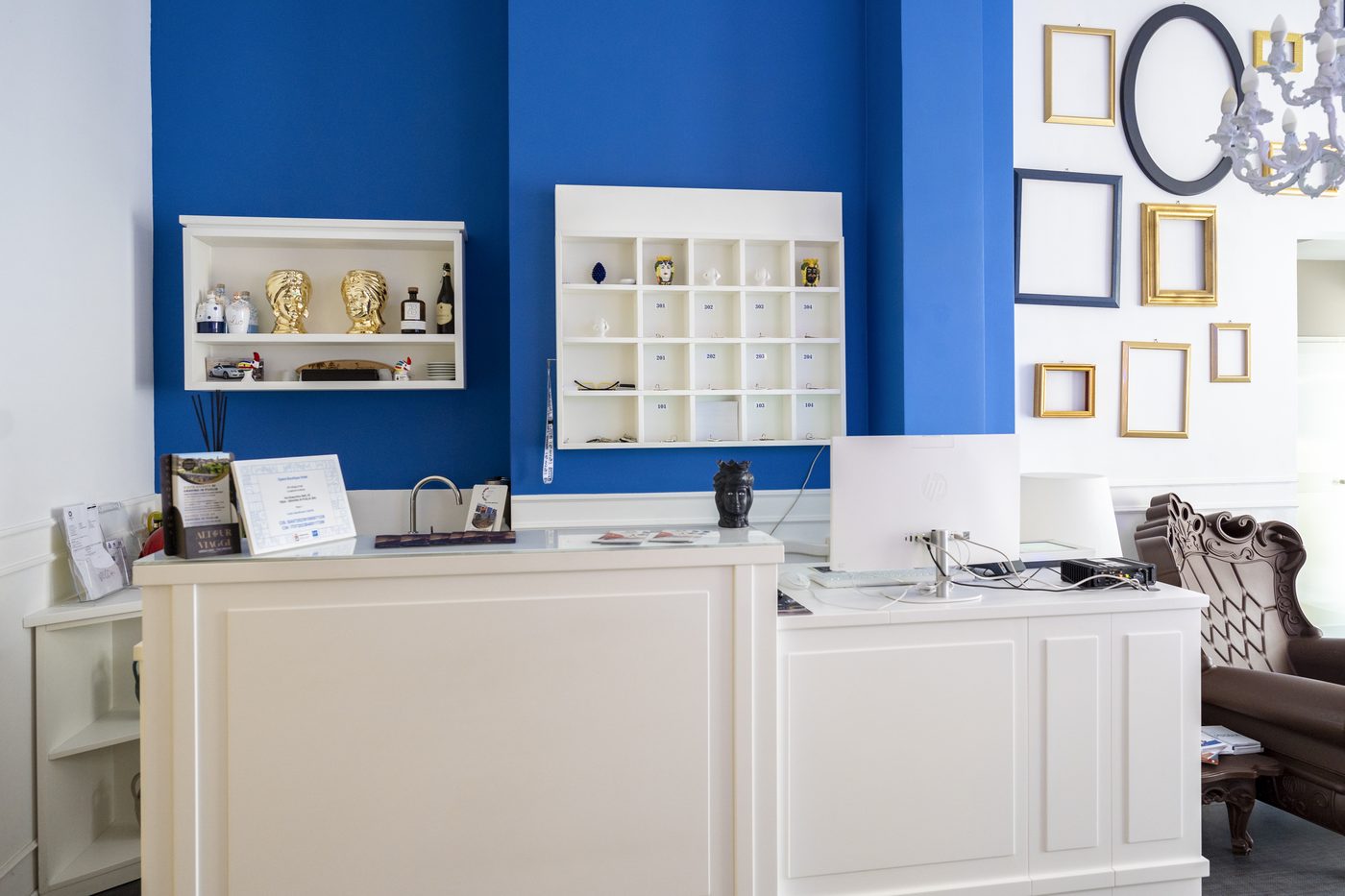 Reception dell'hotel con parete blu e cornici decorative
